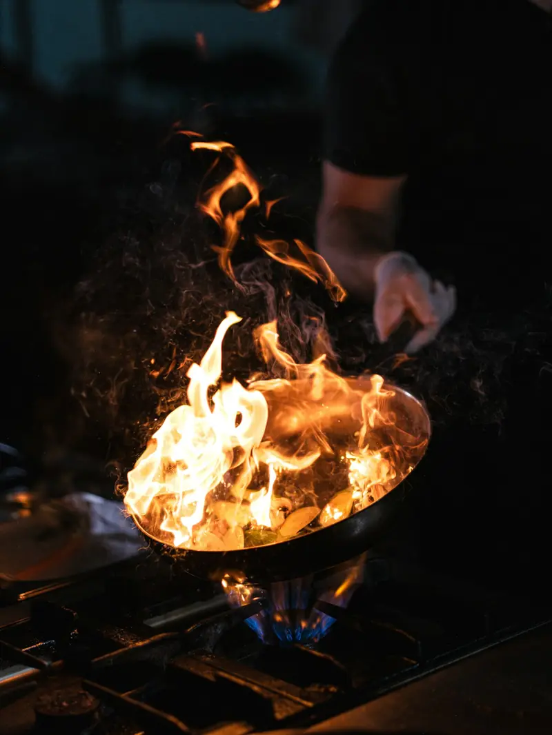 Flames rising from a wok over a high heat burner
